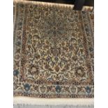 A hand made Persian woollen and part silk Isefhan rug the foliate design within matching border on