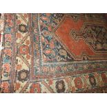 An antique Persian hand made Kurdi rug, the central medallion with ivory border on a red ground.