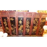 A Chinese carved and lacquered hardwood six fold screen of panelled construction and decorated with