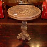 A bone style dragon occasional table raised on an ornately carved column on dragon claw supports