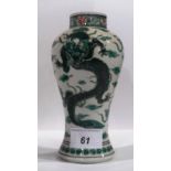 An antique Chinese famille vert vase of baluster form and decorated with flying dragons (as found).