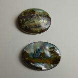 A pair of Russian hand-painted mother-of-pearl brooches decorated with landscapes.