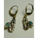 A pair of 9ct gold earrings of snake form and inset with emeralds and diamonds