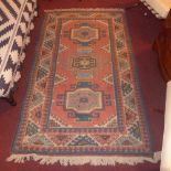 A Kazak rug having beige field and multi coloured repeating geometric motifs