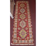 A Persian Heriz design runner with five medallions on a red field surrounded by an ivory border,