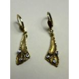 A pair of 9ct gold drop earrings inset with three diamonds each