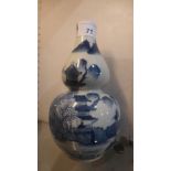 A Chinese blue and white double gourd vase decorated with landscape scenes, with four characters