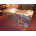 An aluminium clad trunk with rising lid, twin handles, and leather binding.