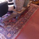 A fine central Persian Kashan carpet with central sapphire floral medallion on a rouge field with