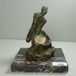 A bronze figure of a faun holding an inkwell liner, raised on square marble base.