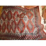 A small Bokhara rug having an all over geometric design, along with a larger Turkoman rug,
