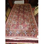 An antique Turkoman rug, the all over geometric design on rouge ground,