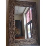 A cotemporary designer wall mirror the rectangular plate within broad frame with applied driftwood