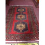 A north west Persian Zanjan rug with chain medallion on a rouge field within stylized geometrical