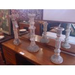 A collection of three carved and painted distressed finish candlesticks