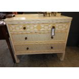 A Continental design cream painted commode of three long drawers on cabriole supports