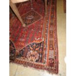 An antique Qashqai carpet, the central medallion on red ground within multiple geometric borders,