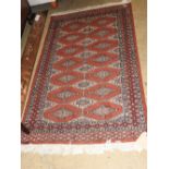 A Bokharra rug, the all over geometric design on rouge ground within multiple corresponding borders,