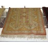A Turkish carpet, the all over geometric design on pink and yellow ground,