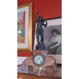 A late 19th century French mantel clock having spelter cherub figure mount atop the rouge marble