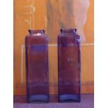 A pair of tall purple glass vases