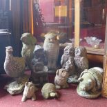 A collection of reconstituted stone garden ornaments in the form of animals, including owls,