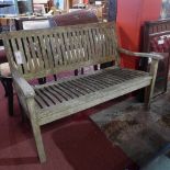 A weathered teak garden bench of slatted construction