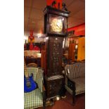 An early 19th century carved oak and mahogany long case clock with circular engraved brass Roman