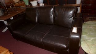 A contemporary designer three seater sofa of angular form upholstered in dark brown leather and