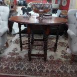 A 1940's oak drop flap dining table rais