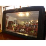 An overmantel mirror with heavy black pa