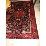 A fine North West Persian Nahawand rug with central pole medallion and repeating petal motifs on a