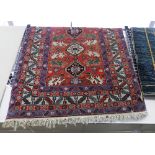 A Kazak design rug, the central pole medallion on rouge ground within multiple borders ,