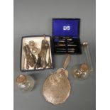 Two silver topped perfume bottles, a silver hand mirror,
