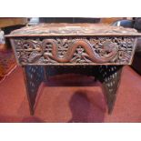 A Chinese profusely carved hardwood desk having entwining dragon detail in relief