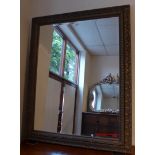 A 20th Century overmantel mirror the bevelled plate within ornately carved oak frame with acenthus