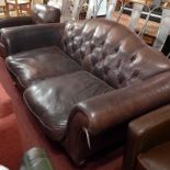 A Laura Ashley two seater sofa upholstered in buttoned brown leather and raised on turned supports