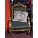 A French carved giltwood armchair upholstered in green damask and raised on reeded supports
