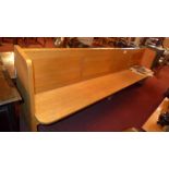 A light oak church pew, of elongated form and with panelled back, 9 foot long.