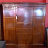 A Victorian mahogany triple wardrobe the dentil cornice above central panel door above four drawers
