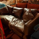 A contemporary designer three seater sofa of angular form upholstered in brown leather on chromed