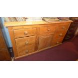 A Victorian pine dresser base fitted arrangement of seven drawers with knob handles and central