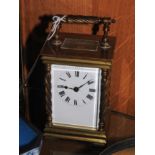An early 20th century brass carriage clock with twisted columns and moulded handle.