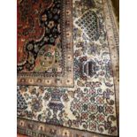 A Persian wool and silk Qum rug, the central medallion on salmon ground,
