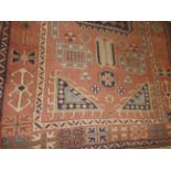 An Afghan rug, the all over geometric design on terracotta ground,