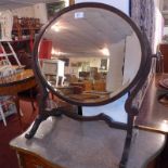 An early 20th century walnut swing frame toilet mirror with oval bevelled plate.