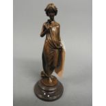 A bronzed figure of a young lady with a