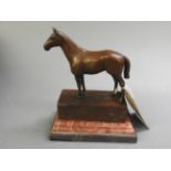 A bronzed figure on a horse on a marble