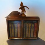 A miniature brass glazed bookcase contai