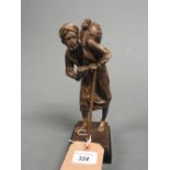 A bronzed figure of a beggar with a bowl